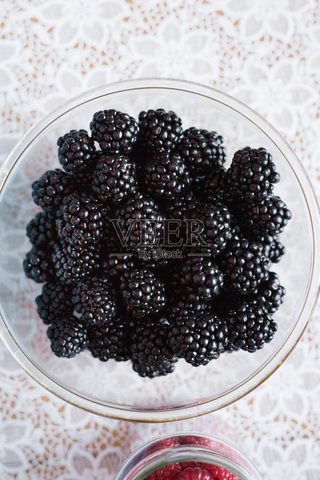 新鲜的有机黑莓放在桌子上的透明盘子里照片摄影图片