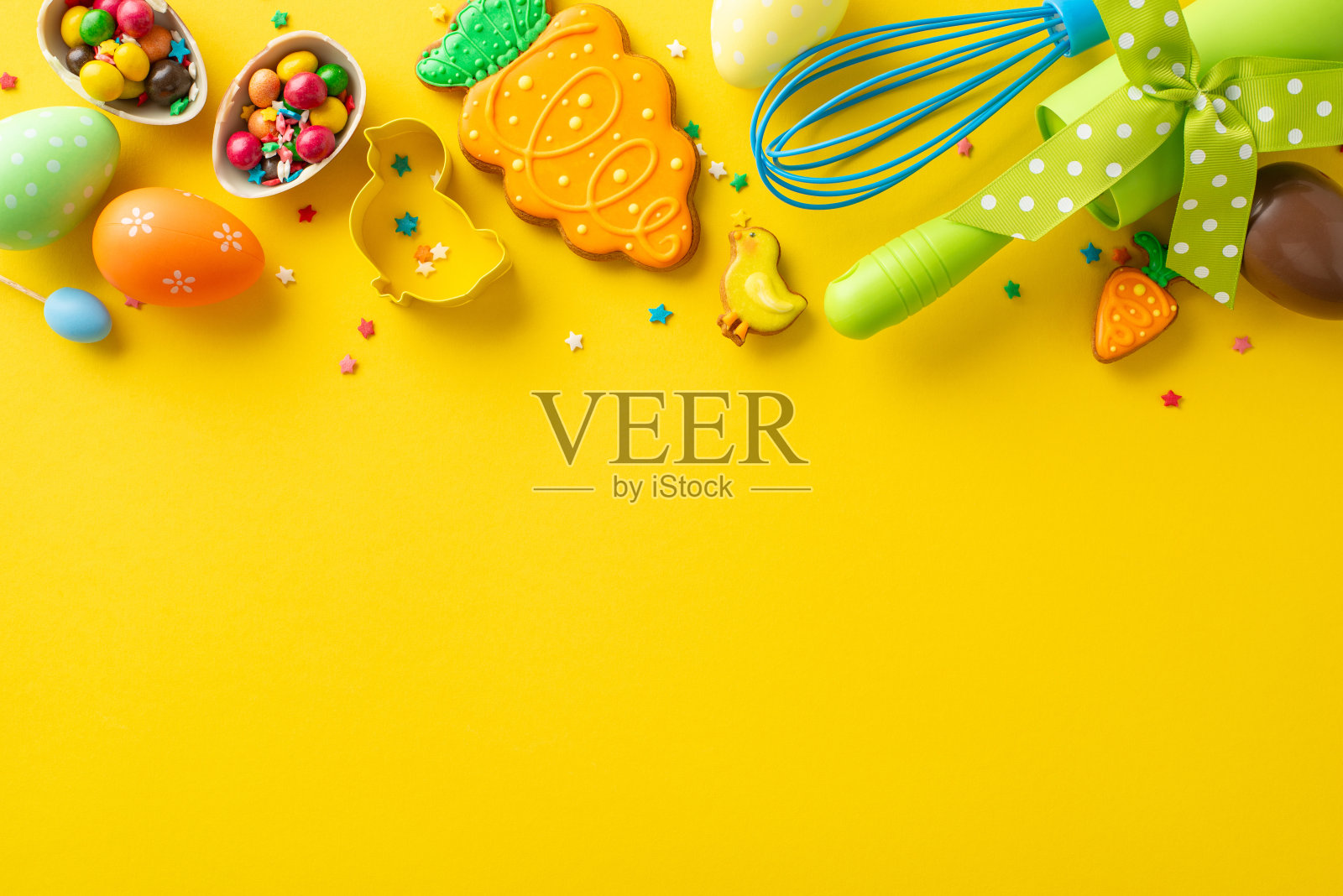 搅拌，卷，为复活节烘焙!节日烘焙桌与基本工具的俯视图。迷人的姜饼，饼干切割器，巧克力蛋，点缀在鲜艳的黄色背景上。广告位照片摄影图片