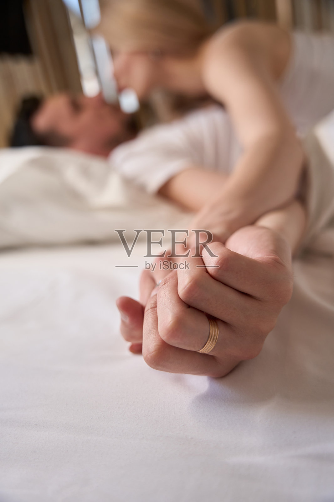 一对漂亮的夫妇在一张大床上玩得很开心照片摄影图片