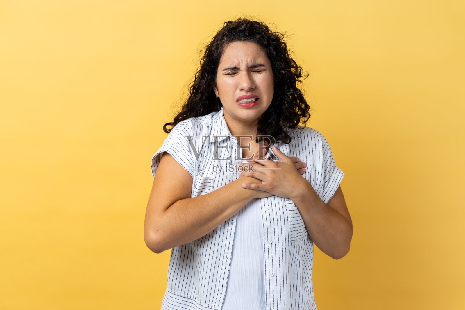 女人手捂胸口，感到心脏剧痛，有心脏病发作的风险照片摄影图片