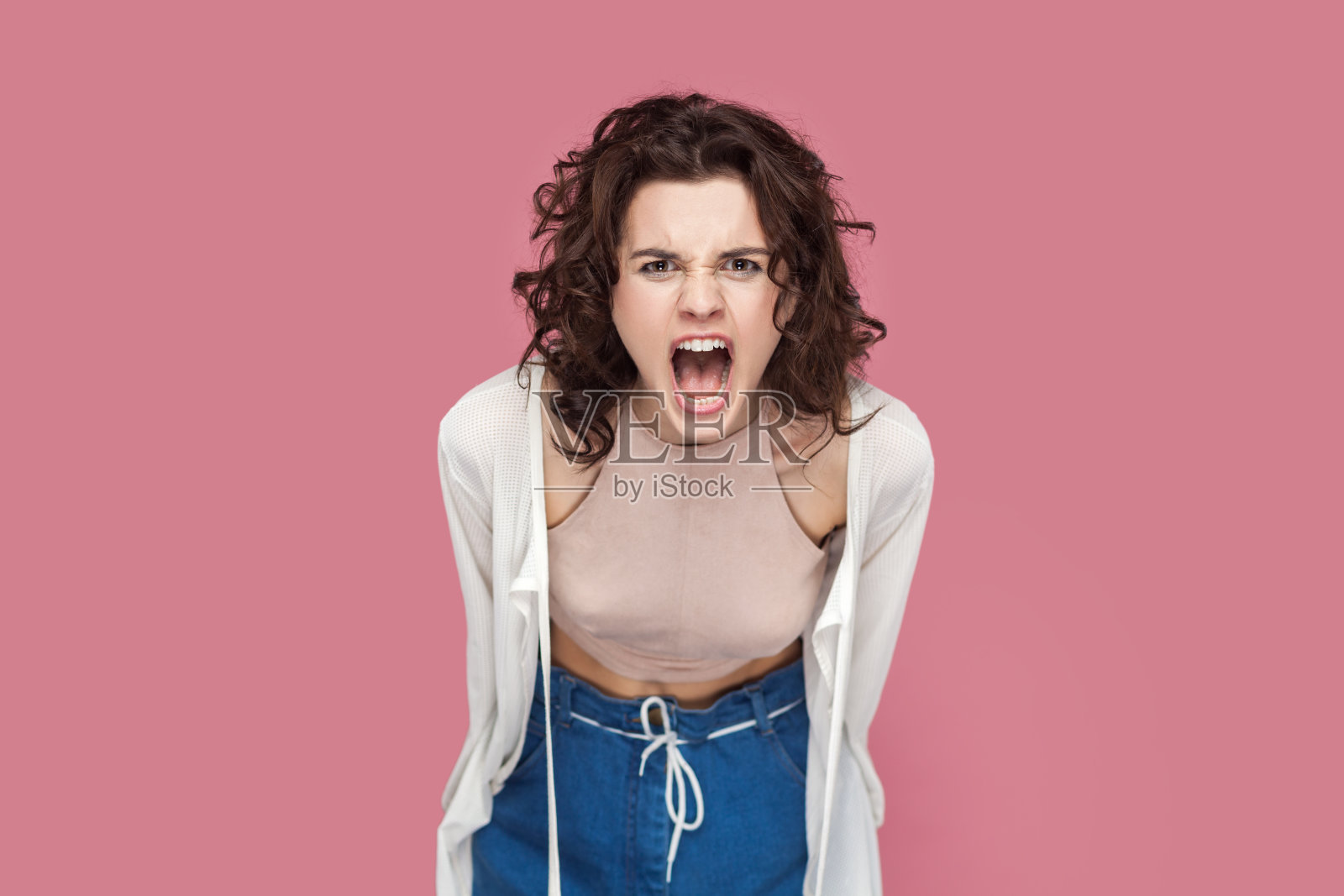 愤怒的女人站着与人争吵，充满仇恨和攻击性地尖叫照片摄影图片