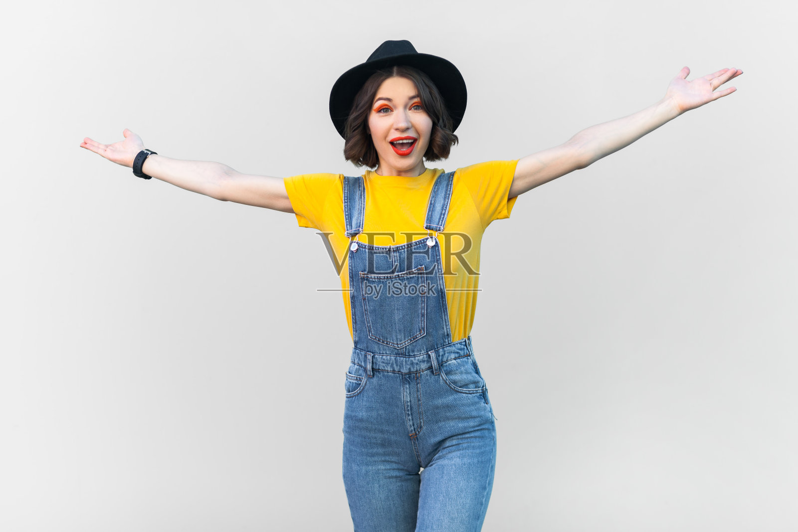 兴奋快乐的时髦女人张开双臂，摆出欢迎的姿态，邀请。照片摄影图片