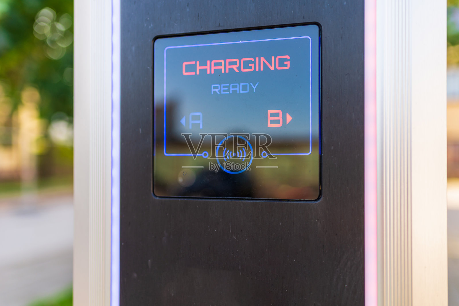 电动汽车电池充电器插座带负载指示灯，铭文充电选择性聚焦，户外拍摄。照片摄影图片