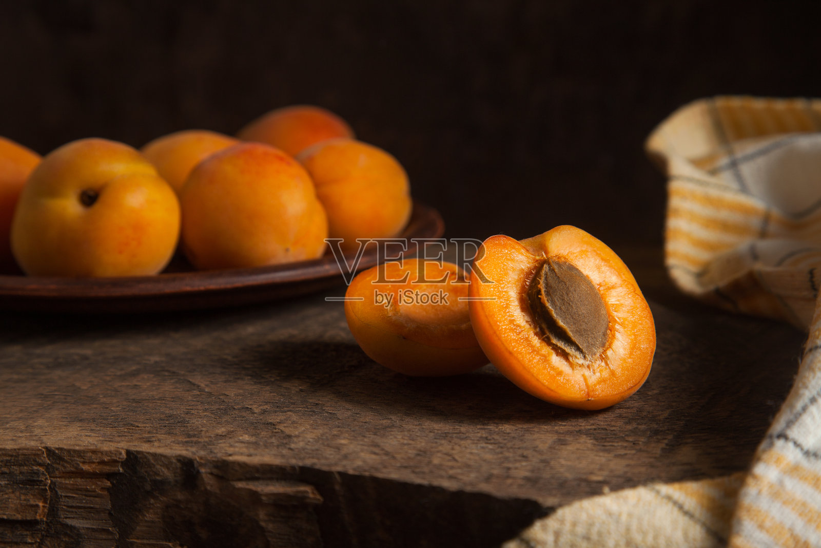 木制背景上的杏子。照片摄影图片