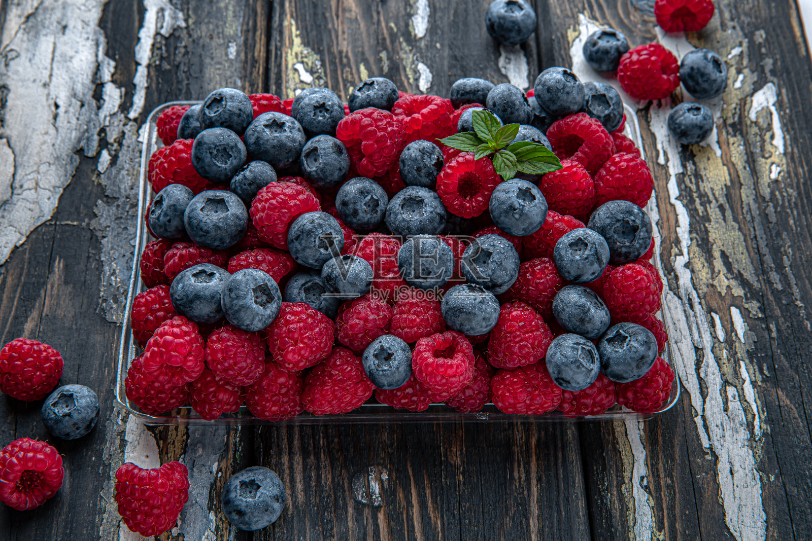 蓝莓和覆盆子的混合。新鲜、成熟、多汁的浆果。照片摄影图片