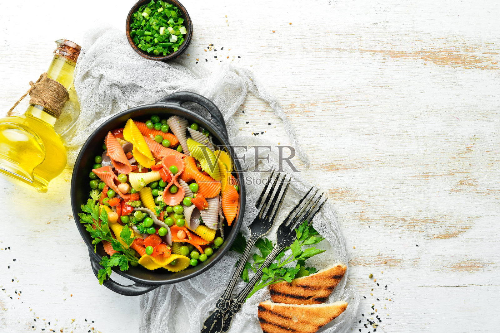 黑色的碗里有豌豆和蔬菜的彩色面食。前视图。文本的自由空间。照片摄影图片