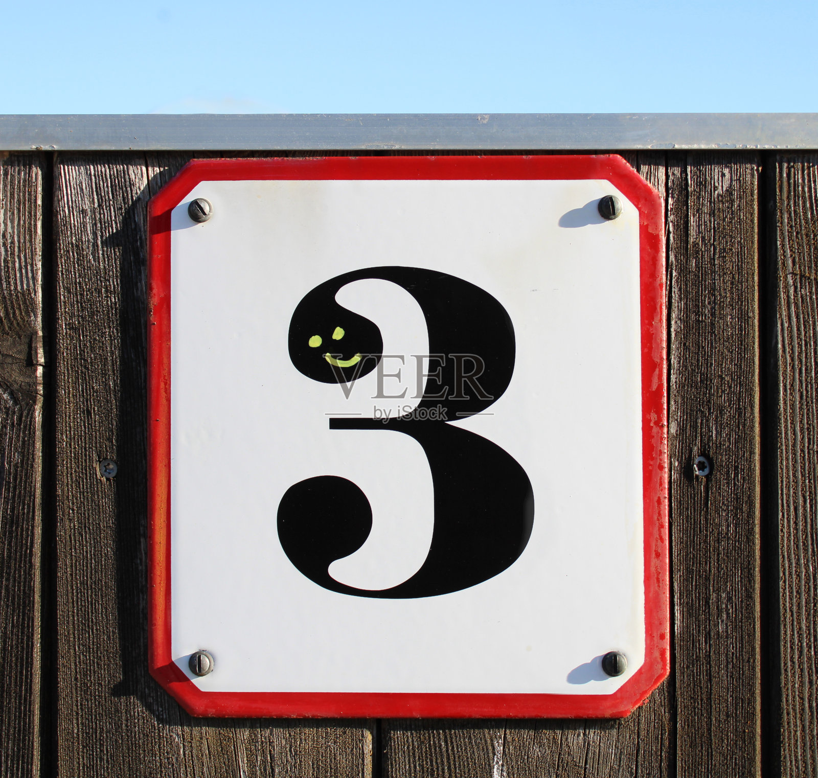 木墙上的3号金属标牌，蓝天下有一个笑脸照片摄影图片