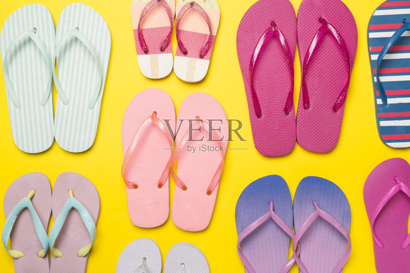 许多明亮的人字拖在彩色背景，俯视图照片摄影图片