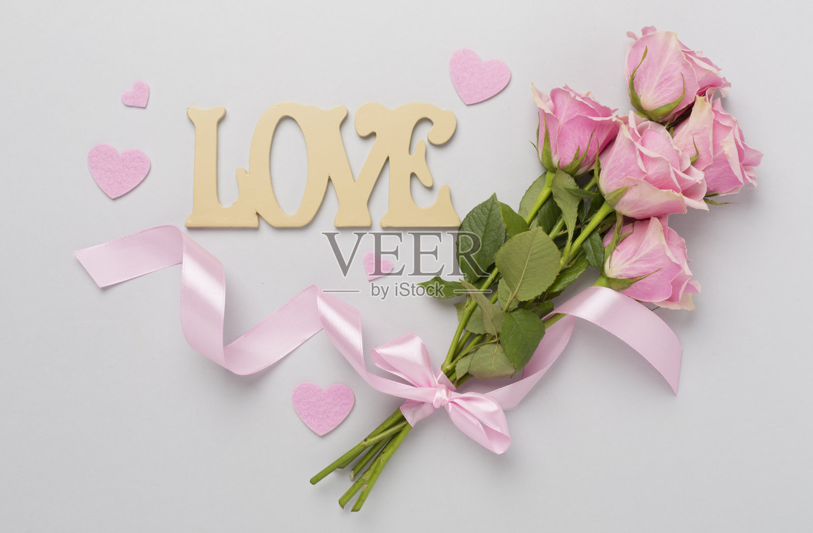 粉红色玫瑰与心和礼盒的颜色背景，俯视图。情人节概念照片摄影图片