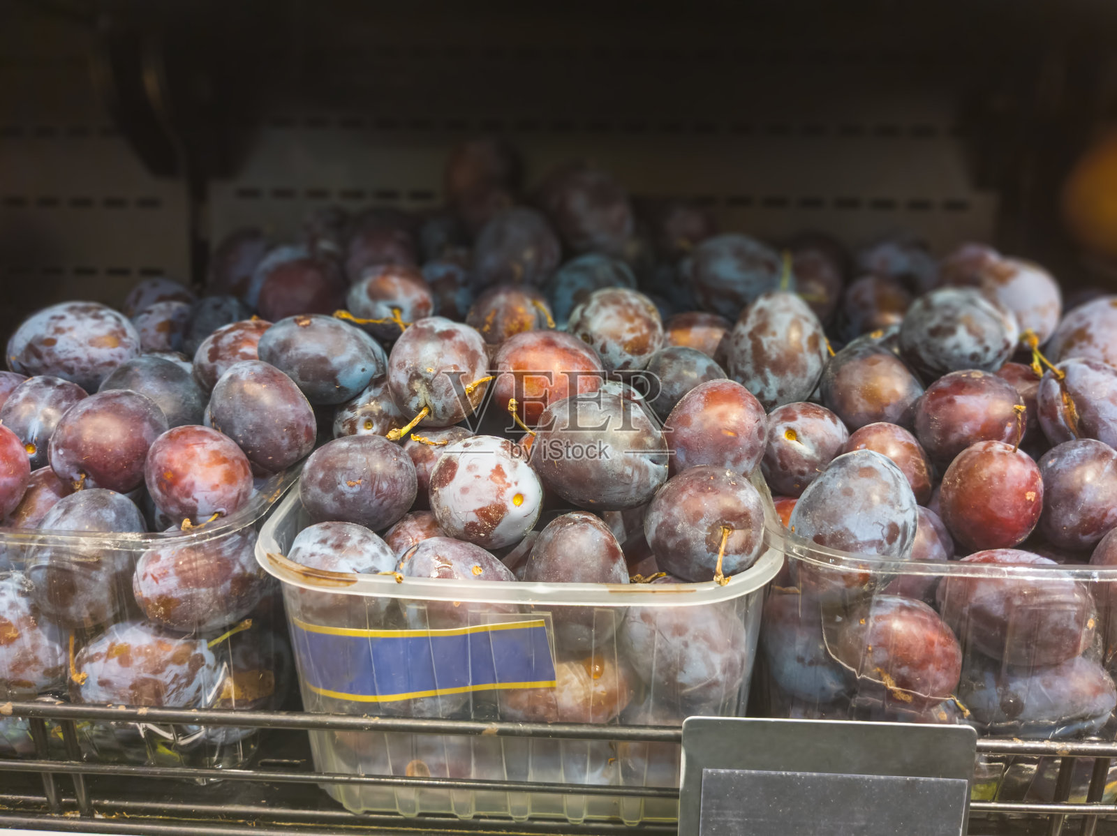 超市水果架上的李子照片摄影图片