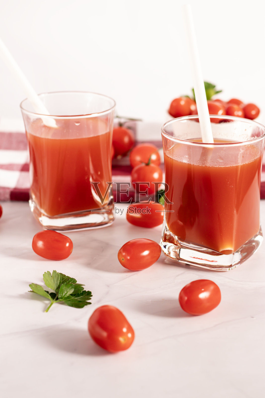 杯子里的番茄汁和新鲜番茄。在白色的背景上。食物照片摄影图片