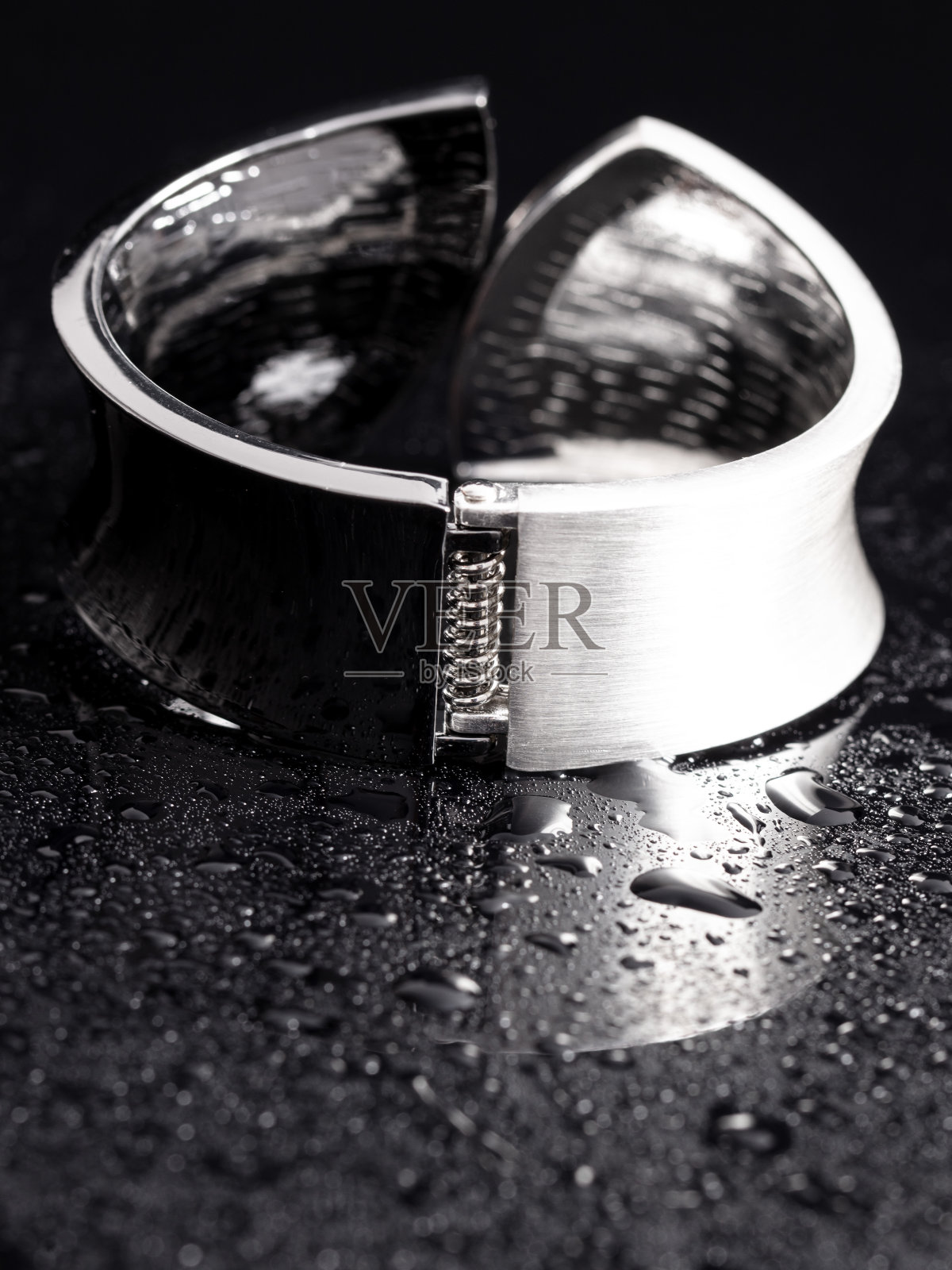 女人的手链在黑色背景的水滴中照片摄影图片