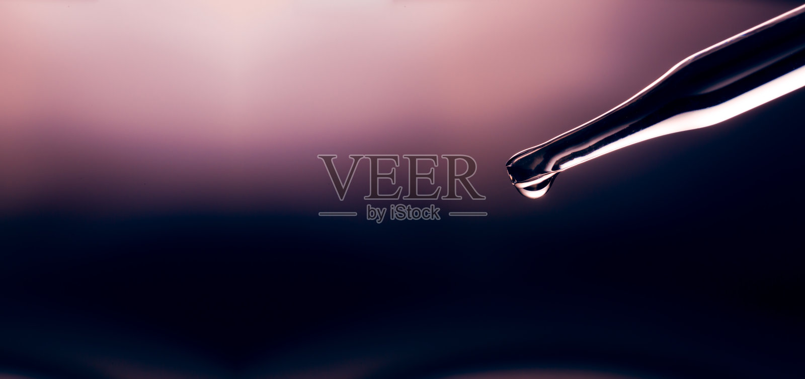 宏观科学实验烧杯特写，俯视图微距镜头移液管在黄色背景的培养皿中将油注入透明液体，抽象护肤化妆品混合概念照片摄影图片