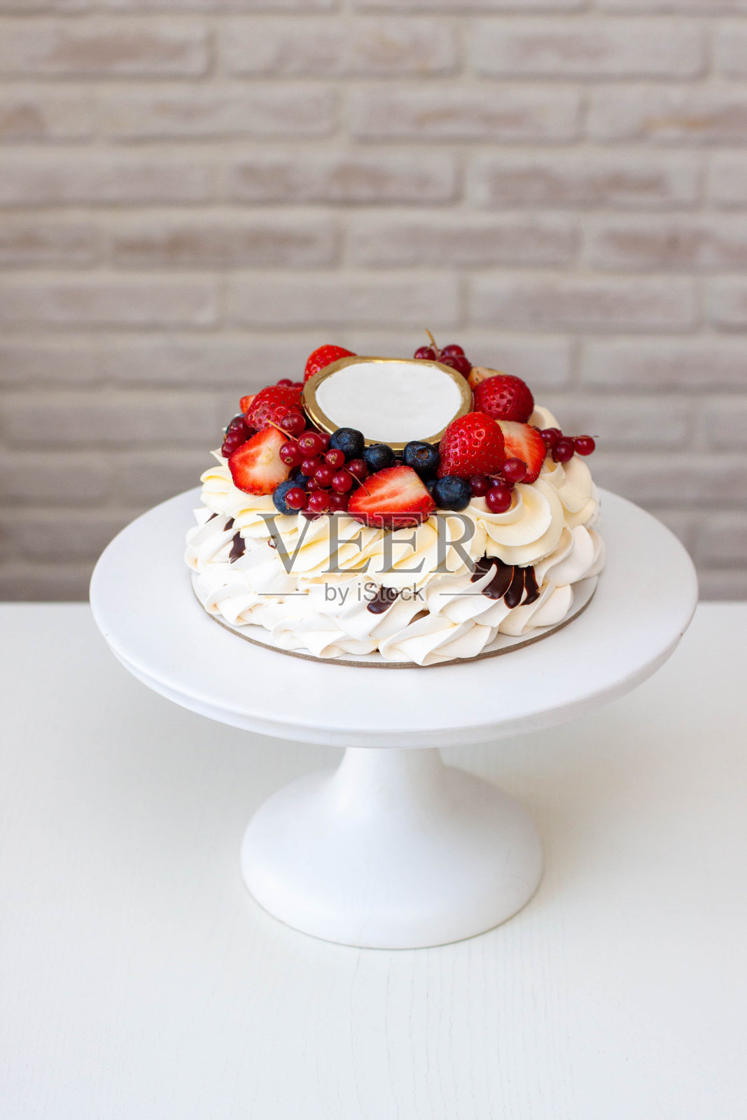 巴甫洛娃蛋糕配鲜奶油奶酪，巧克力酱和新鲜浆果，灰色背景。生日派对的漂亮蛋糕照片摄影图片