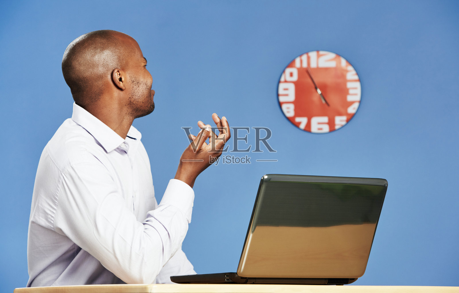 失望的办公室职员看表发现还有五分钟的工作时间照片摄影图片