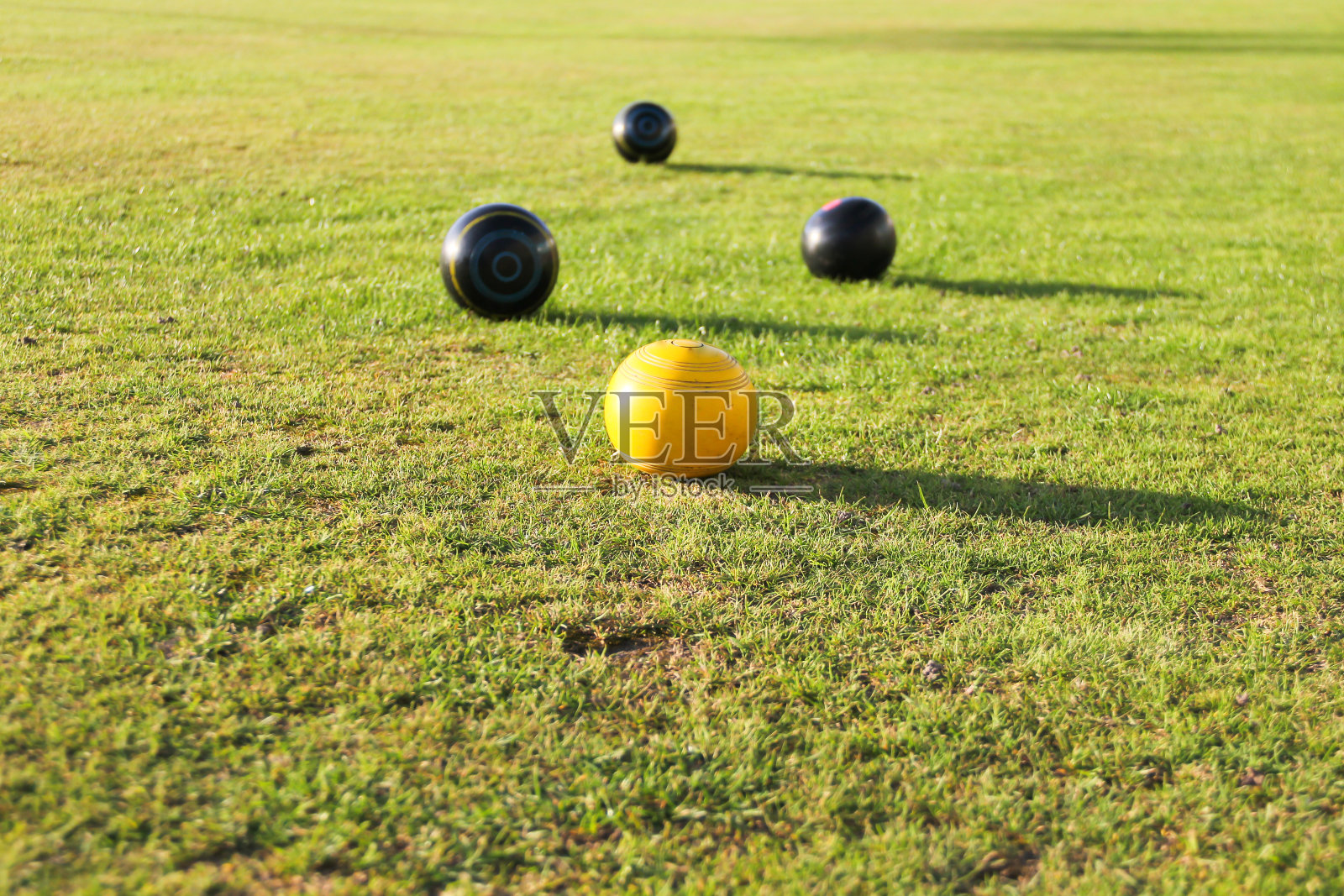 皇冠绿色保龄球-在绿色周围的黄色杰克碗，一个伟大的比赛，许多老年人和年轻人都喜欢。照片摄影图片