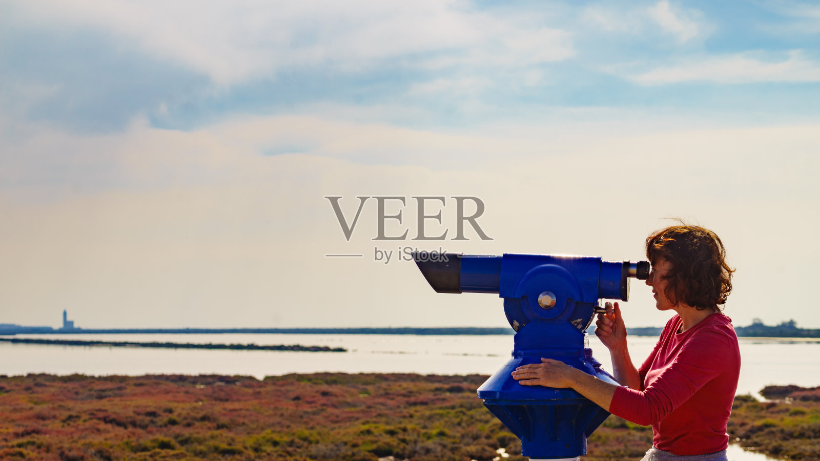 西班牙加塔角，一名妇女在使用旅游双筒望远镜照片摄影图片