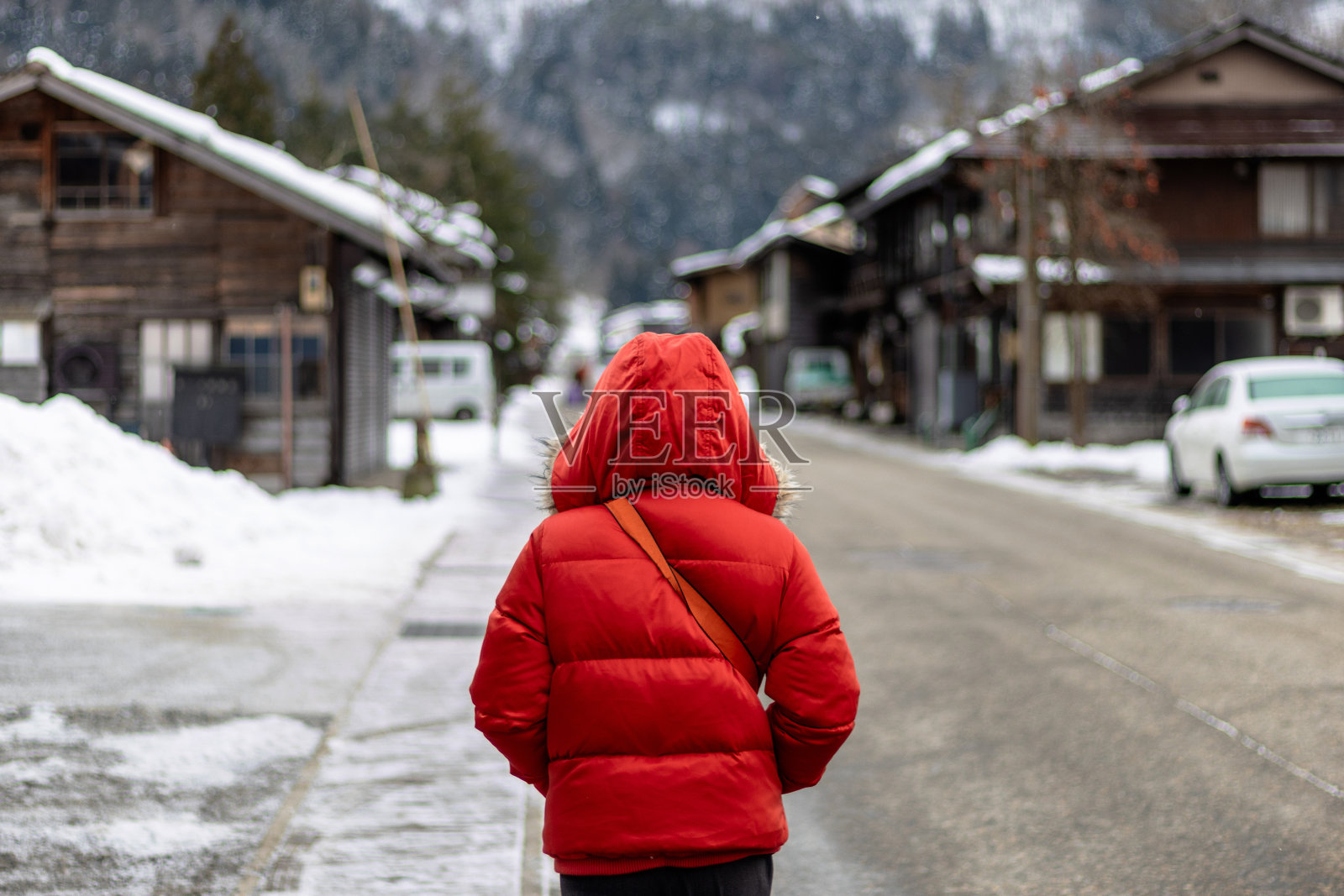 游客们走在白雪覆盖的村庄里照片摄影图片