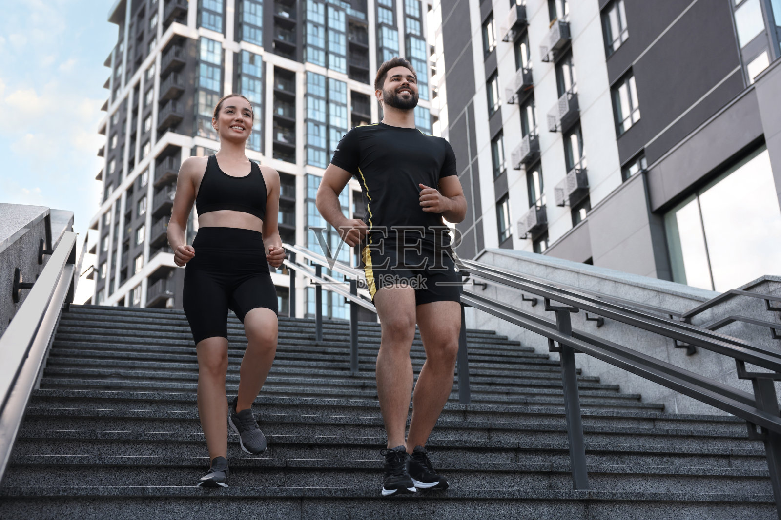 健康的生活方式。幸福的情侣在户外台阶上跑步，低角度观看照片摄影图片