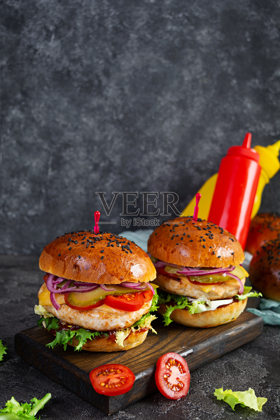 汉堡配鸡排，西红柿，泡菜和生菜。美味的自制汉堡照片摄影图片