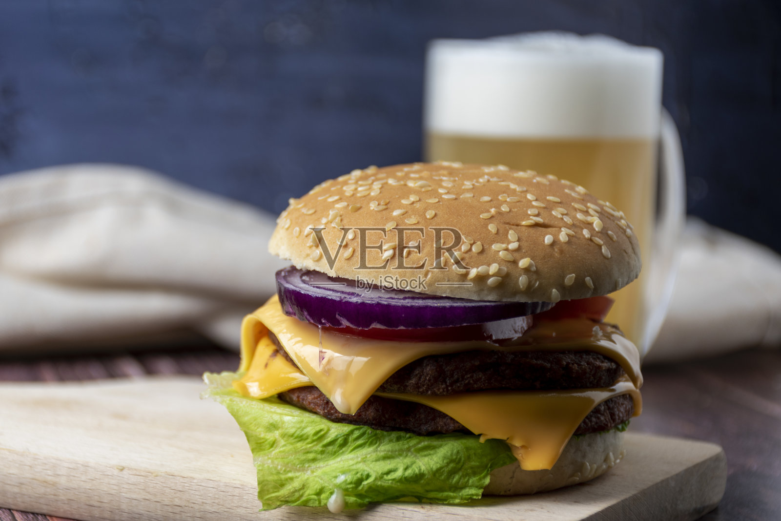 芝士汉堡和啤酒放在桌子上照片摄影图片