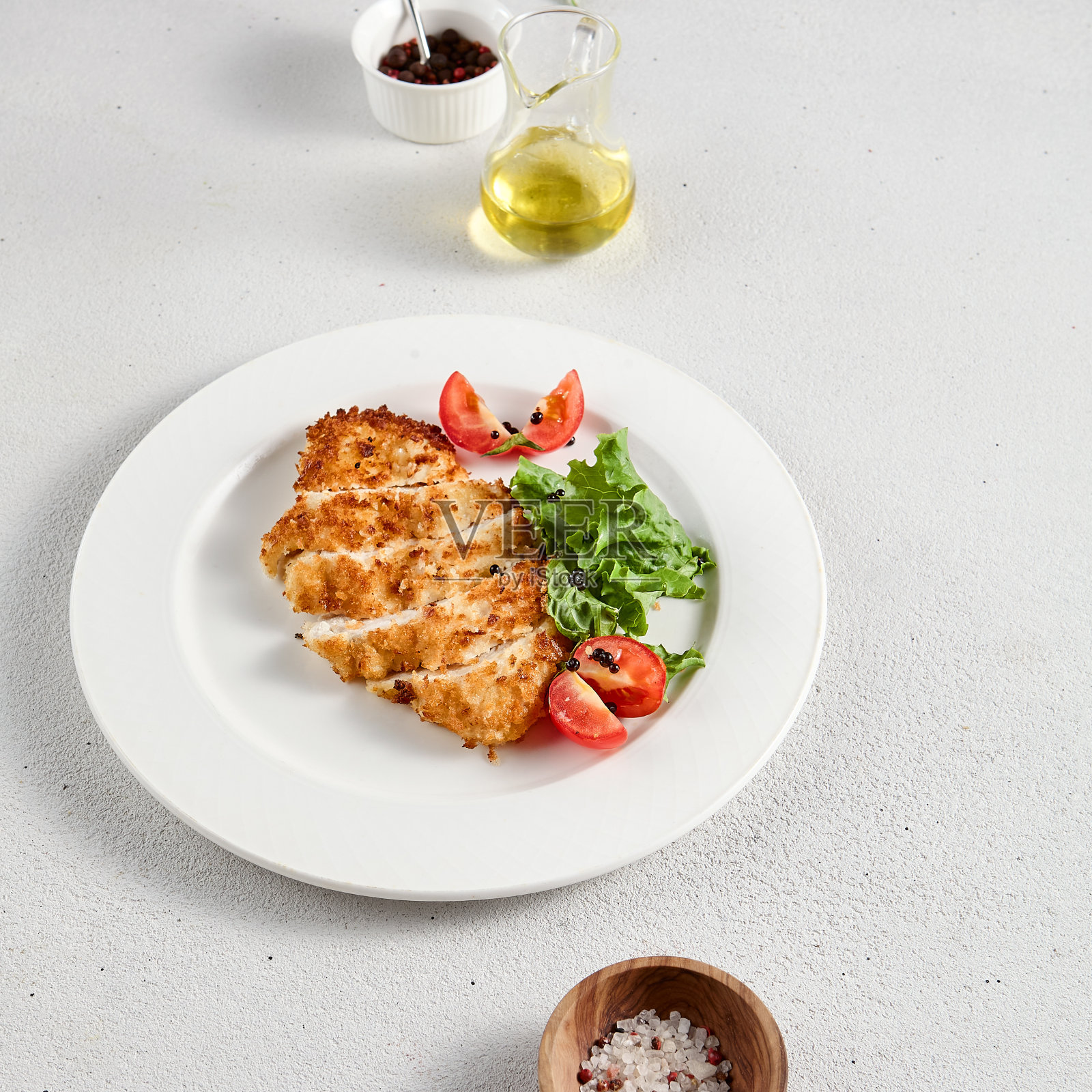 金黄鸡柳配芝士，铺在生菜上，上面撒上圣女果，是食谱和菜单设计的理想选择照片摄影图片