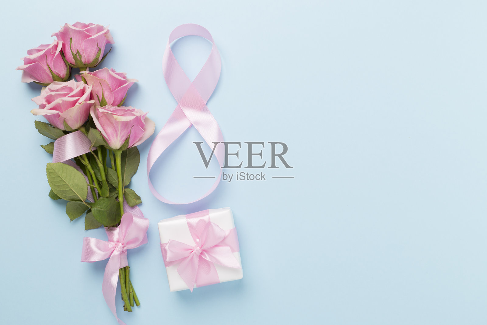 构图与粉红色的玫瑰，礼盒和八个丝带制成的彩色背景，俯视图。妇女节的概念照片摄影图片
