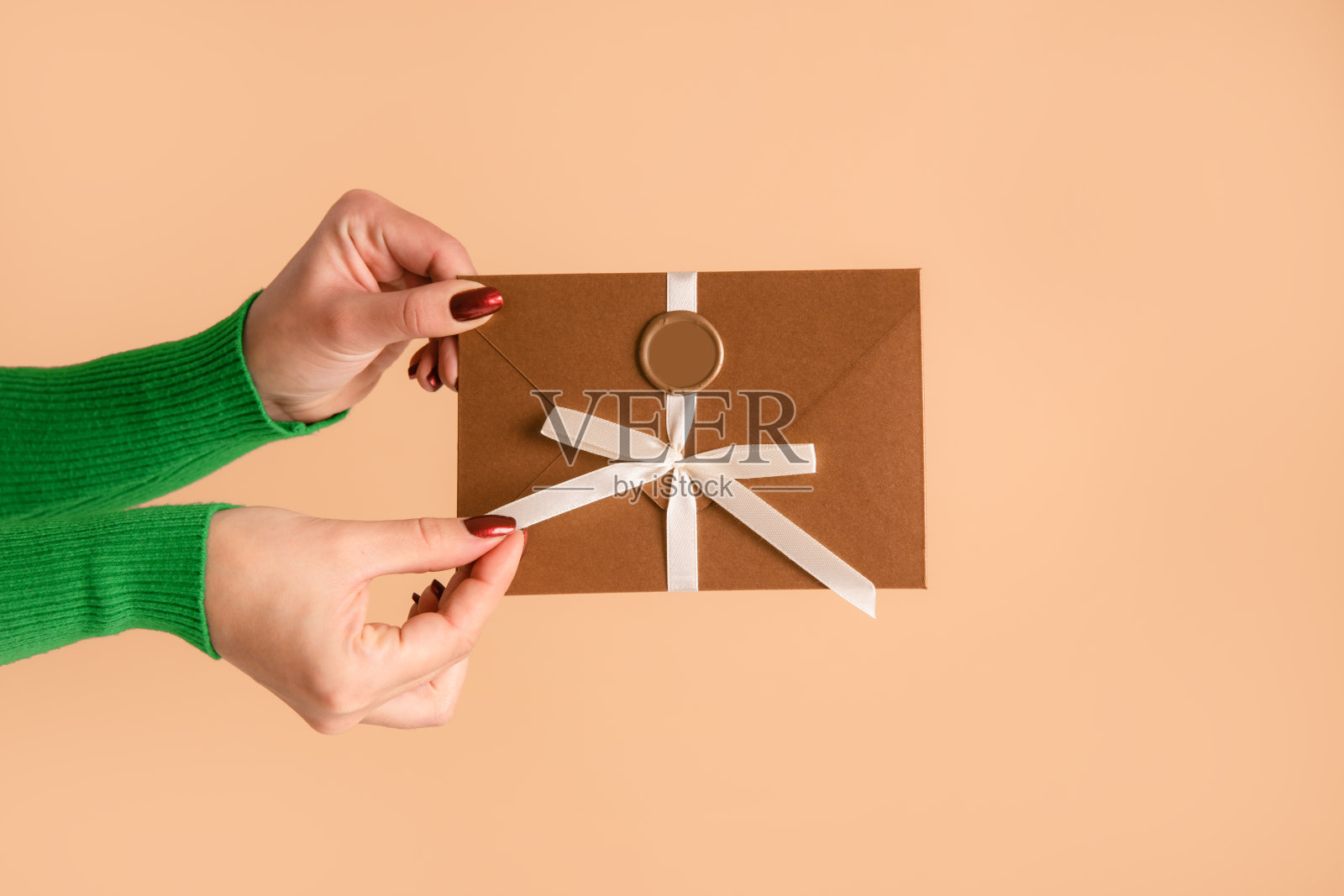 妇女手持折扣券或礼券在信封工作室米色背景照片摄影图片