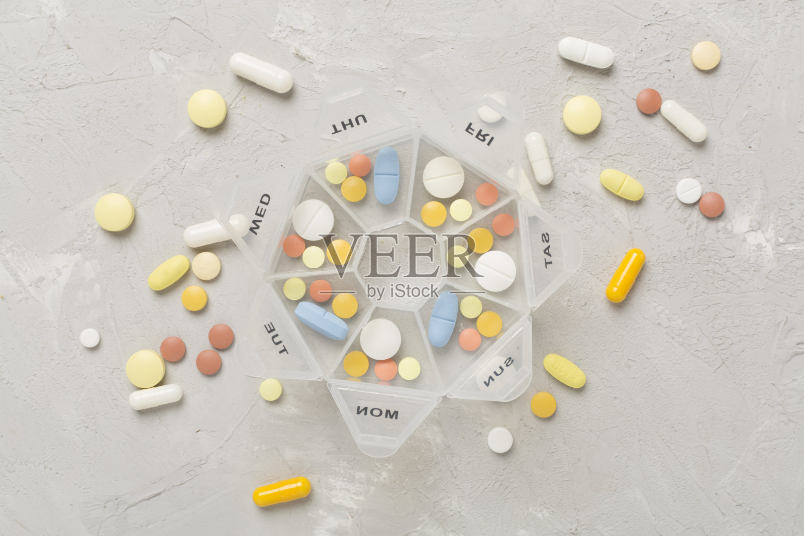 在混凝土背景上放置每日药片整理器，俯视图照片摄影图片