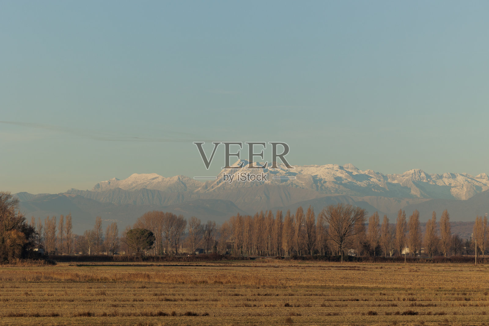 在冬季的早晨，在弗留利-威尼斯朱利亚东部蒙法尔科内附近的农村地区，在晴朗的天空下，朱利安阿尔卑斯山脉的一部分，雪峰照片摄影图片