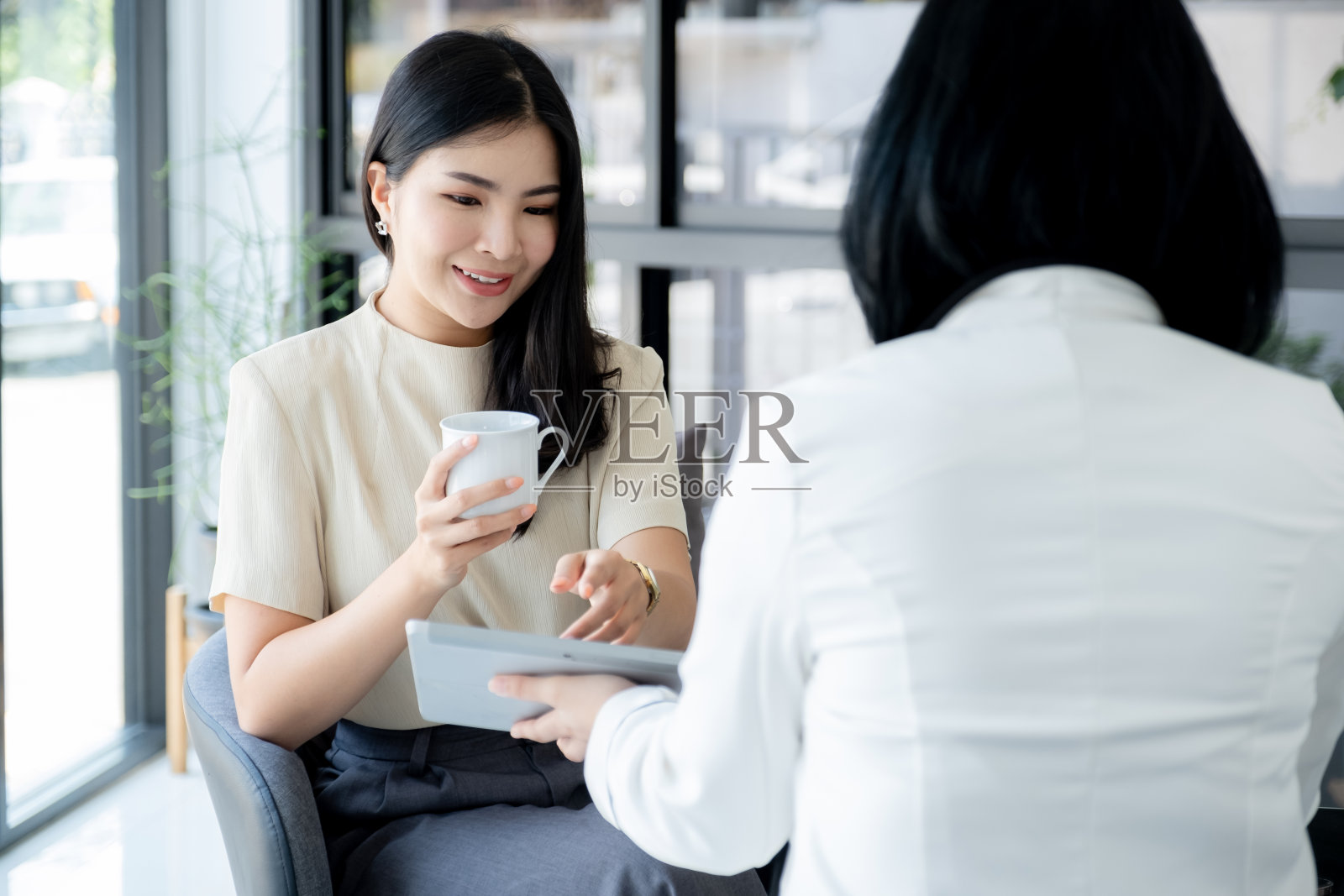 销售人员用平板电脑向女商人介绍产品、服务、旅游、储蓄、金融、投资或人寿保险照片摄影图片