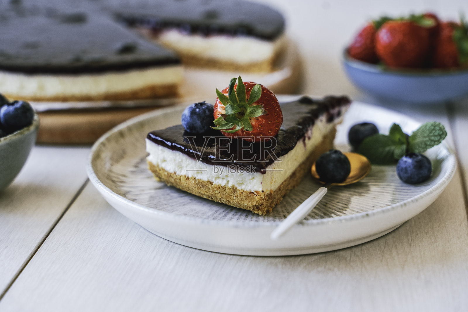 美味的自制芝士蛋糕，配上新鲜的蓝莓和草莓。照片摄影图片