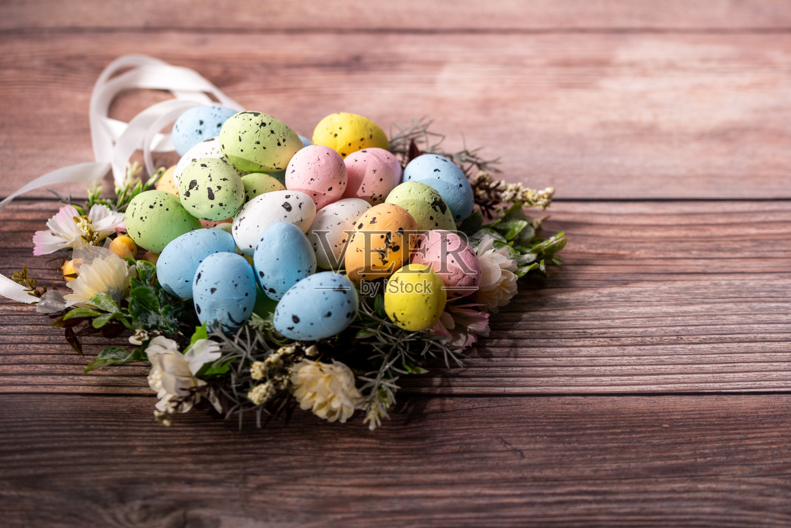 复活节装饰，复活节彩蛋在木制背景上排列成一个窝照片摄影图片
