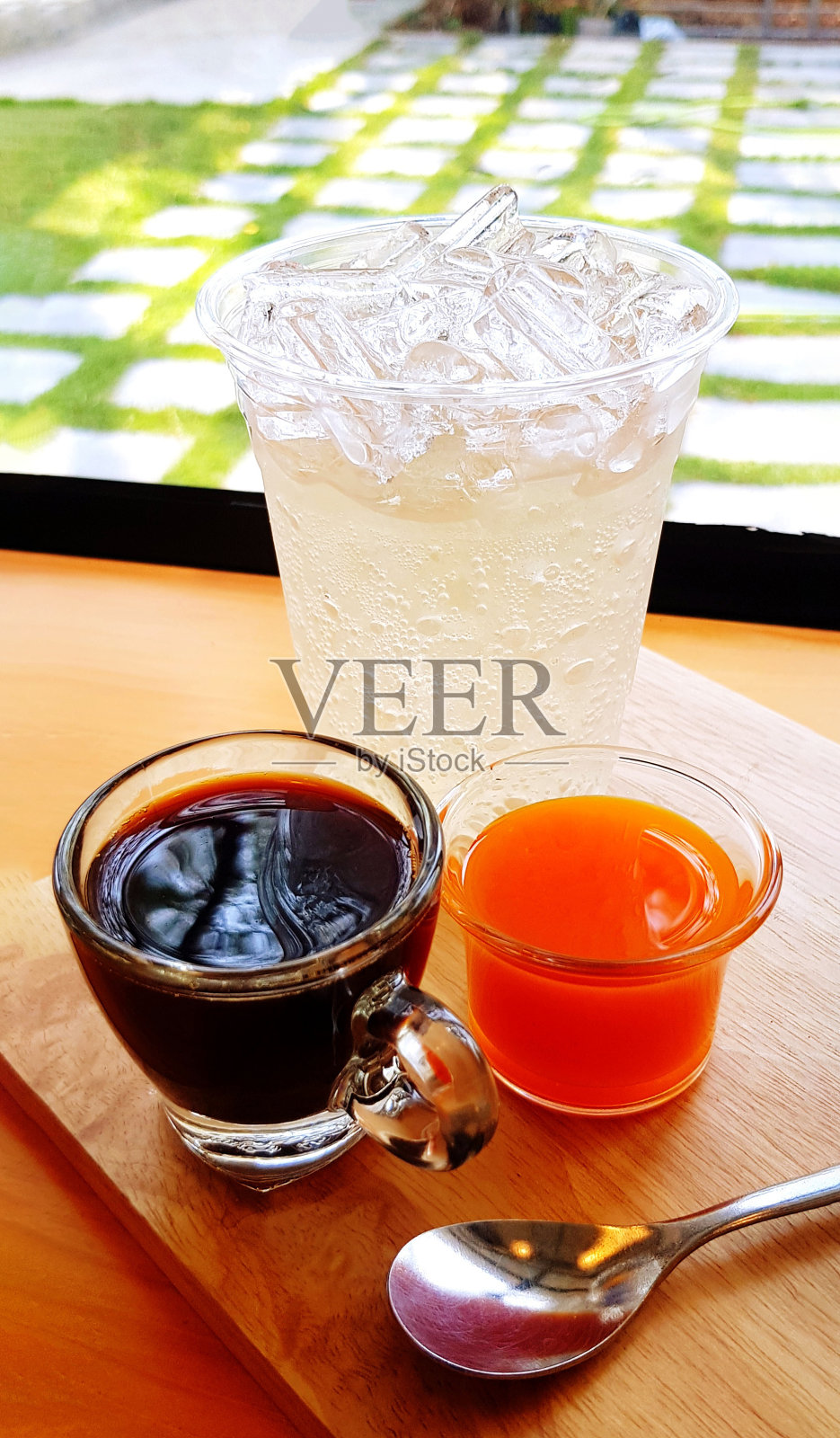 浓缩咖啡加橙汁，冰苏打和勺子放在木制托盘上，上面有复制空间。茶点，饮用水和咖啡厅的概念。照片摄影图片