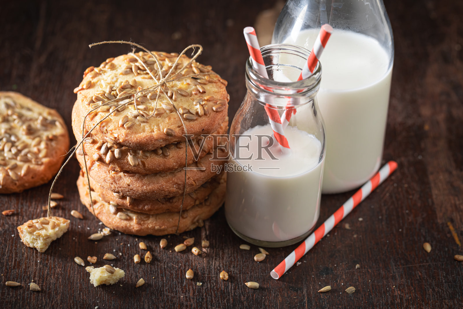 美味的葵花籽饼干和牛奶一起装在瓶子里。照片摄影图片