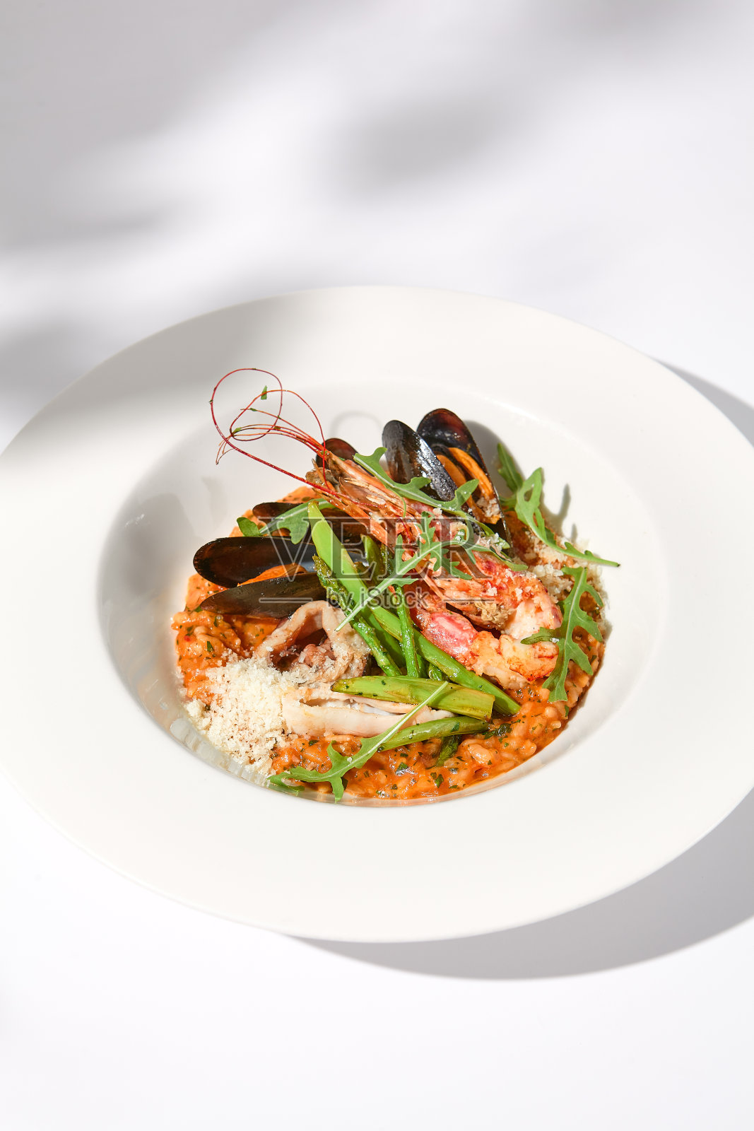 白色背景下的番茄海鲜烩饭照片摄影图片