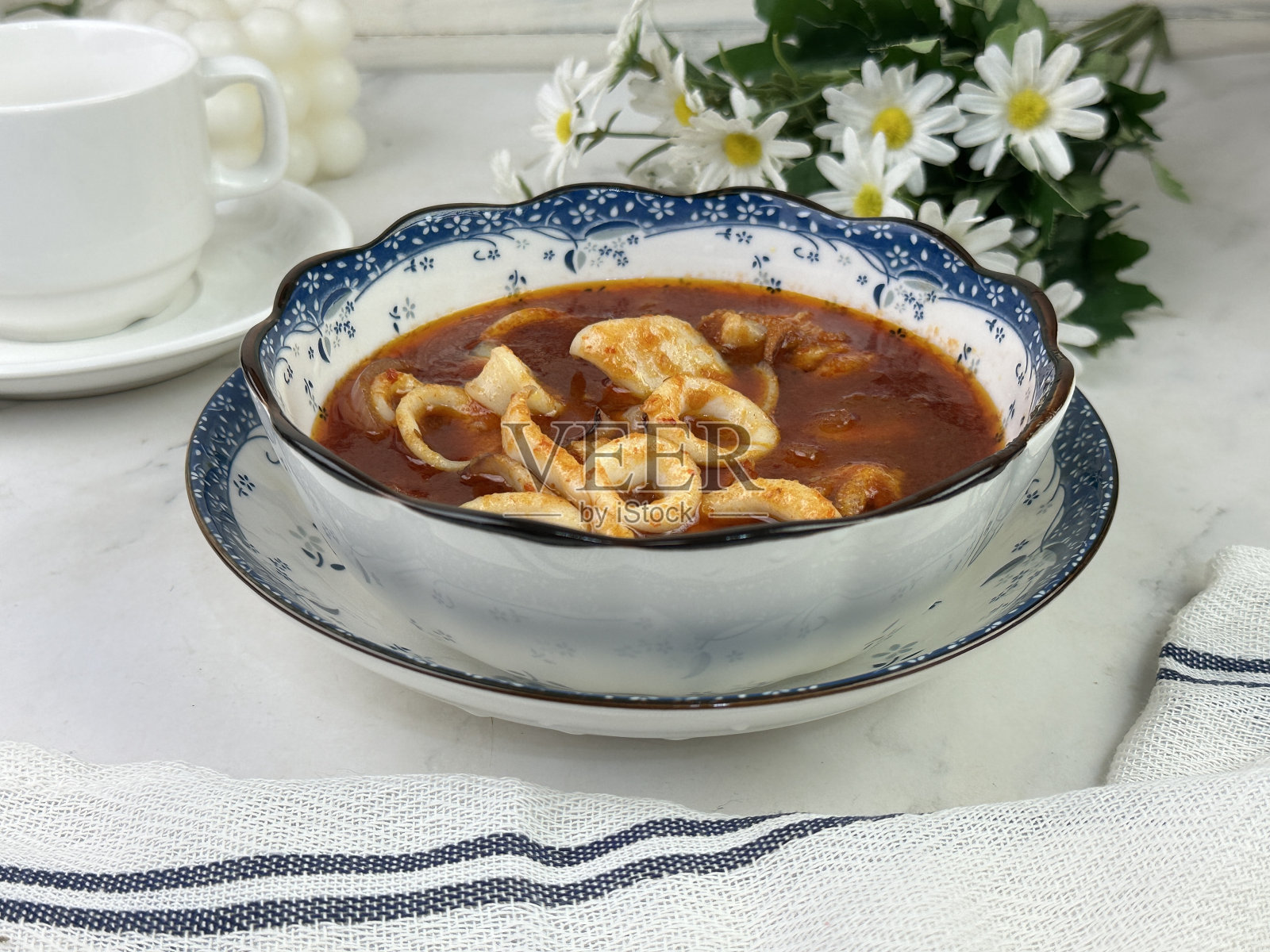 黑底白盘上的马来西亚菜，叫鱿鱼参巴Sotong。这道菜很美味，很容易准备，可以和开兰或其他蔬菜一起食用。照片摄影图片