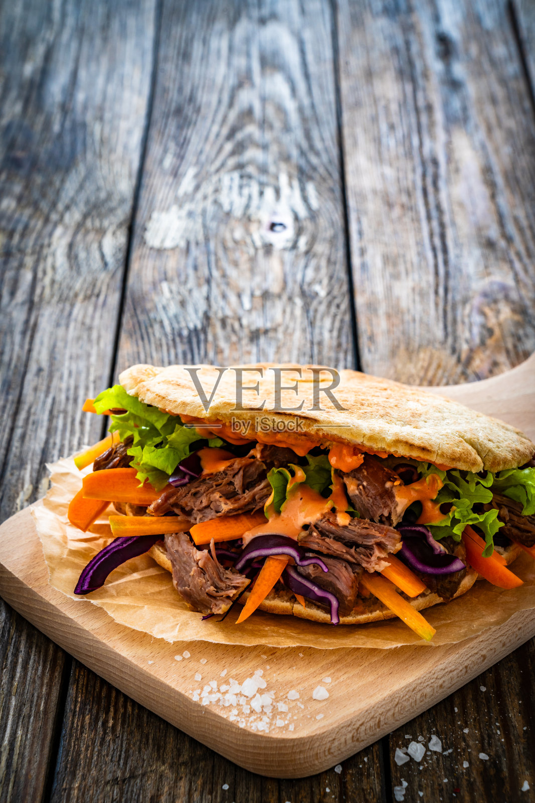 皮塔饼——在木桌上放上牛肉和新鲜蔬菜的大三明治照片摄影图片