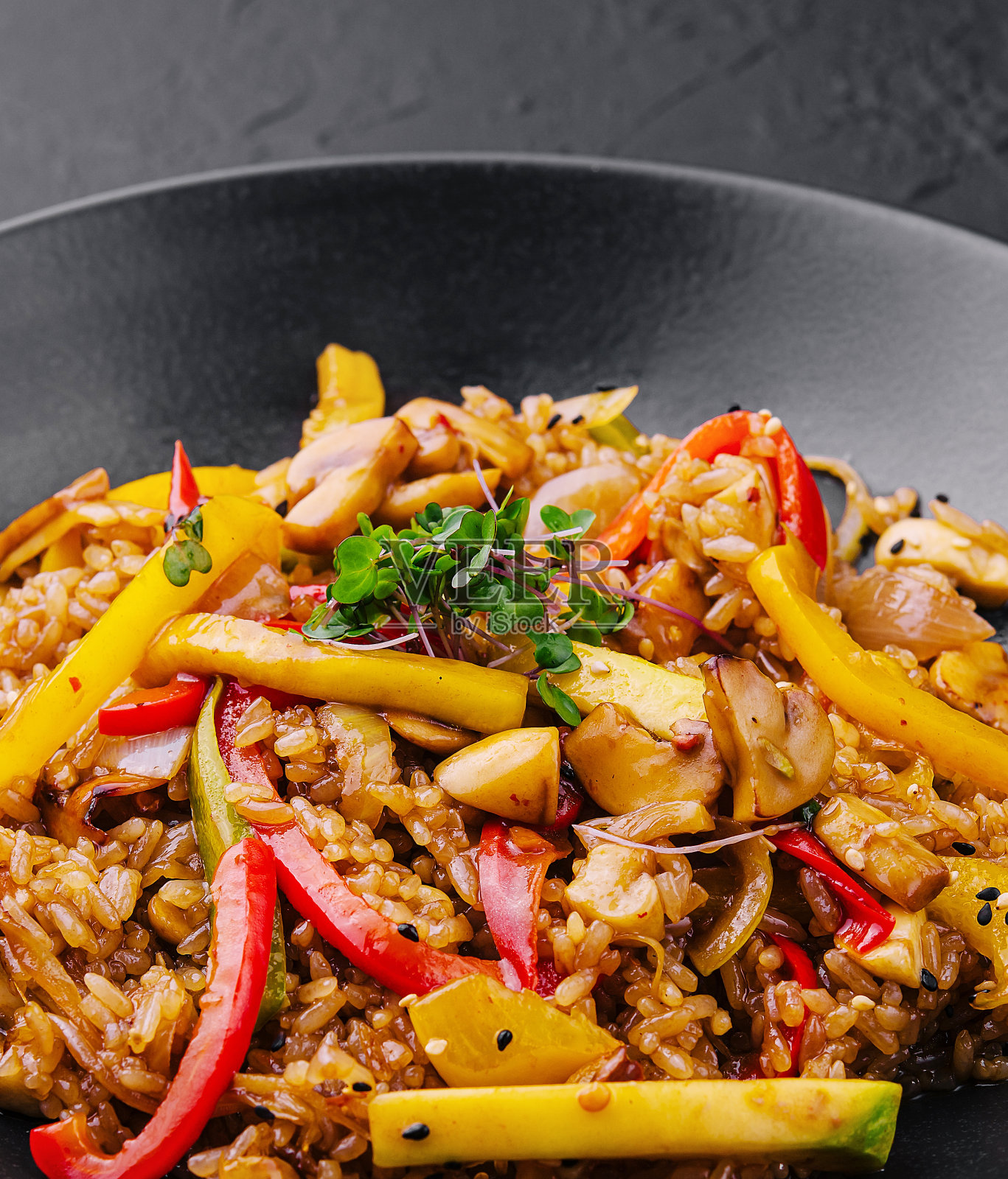 黑色盘子里的中国炒饭配蔬菜照片摄影图片