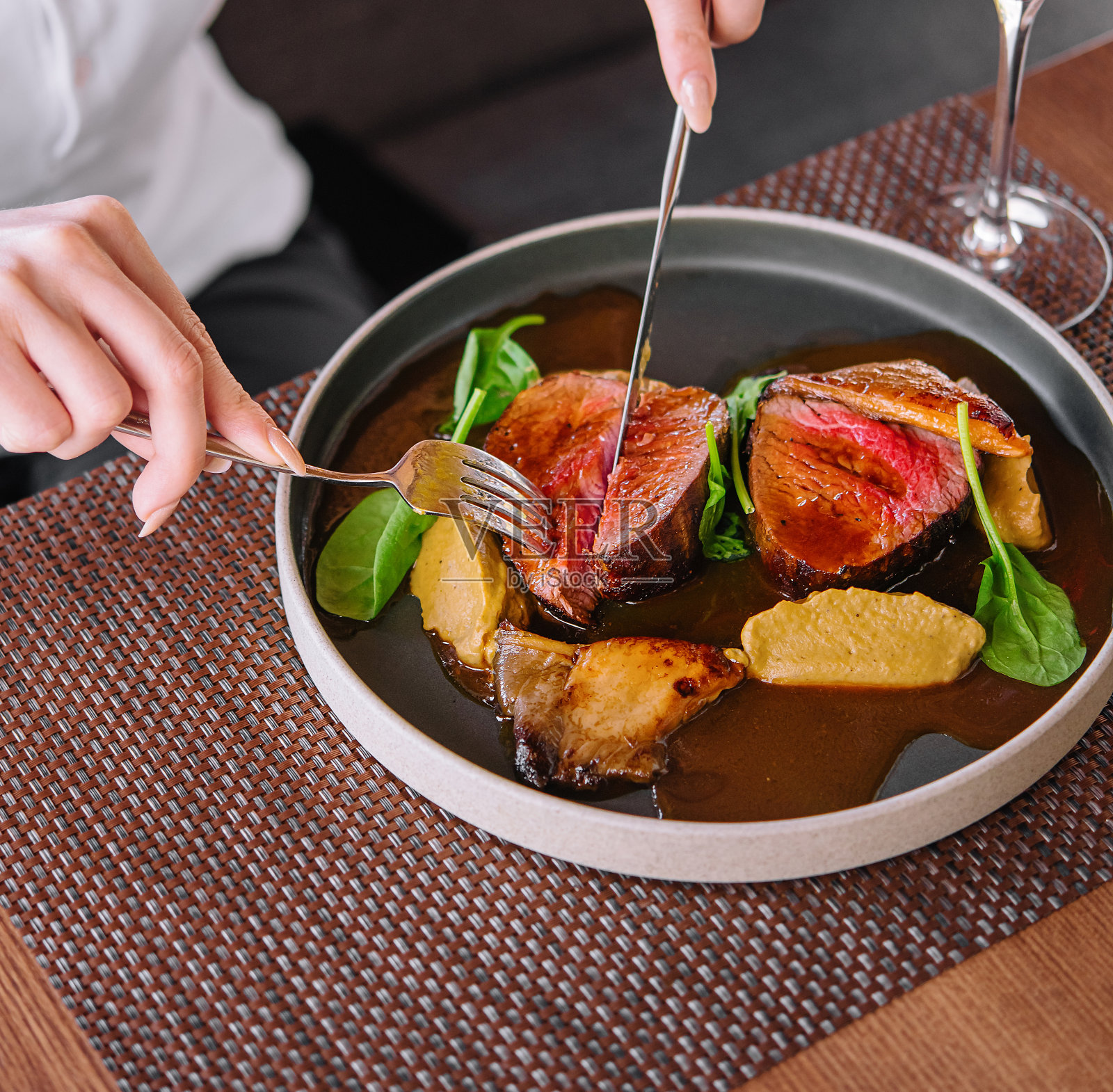 女人手里拿着刀叉，用酒切烤鸭照片摄影图片