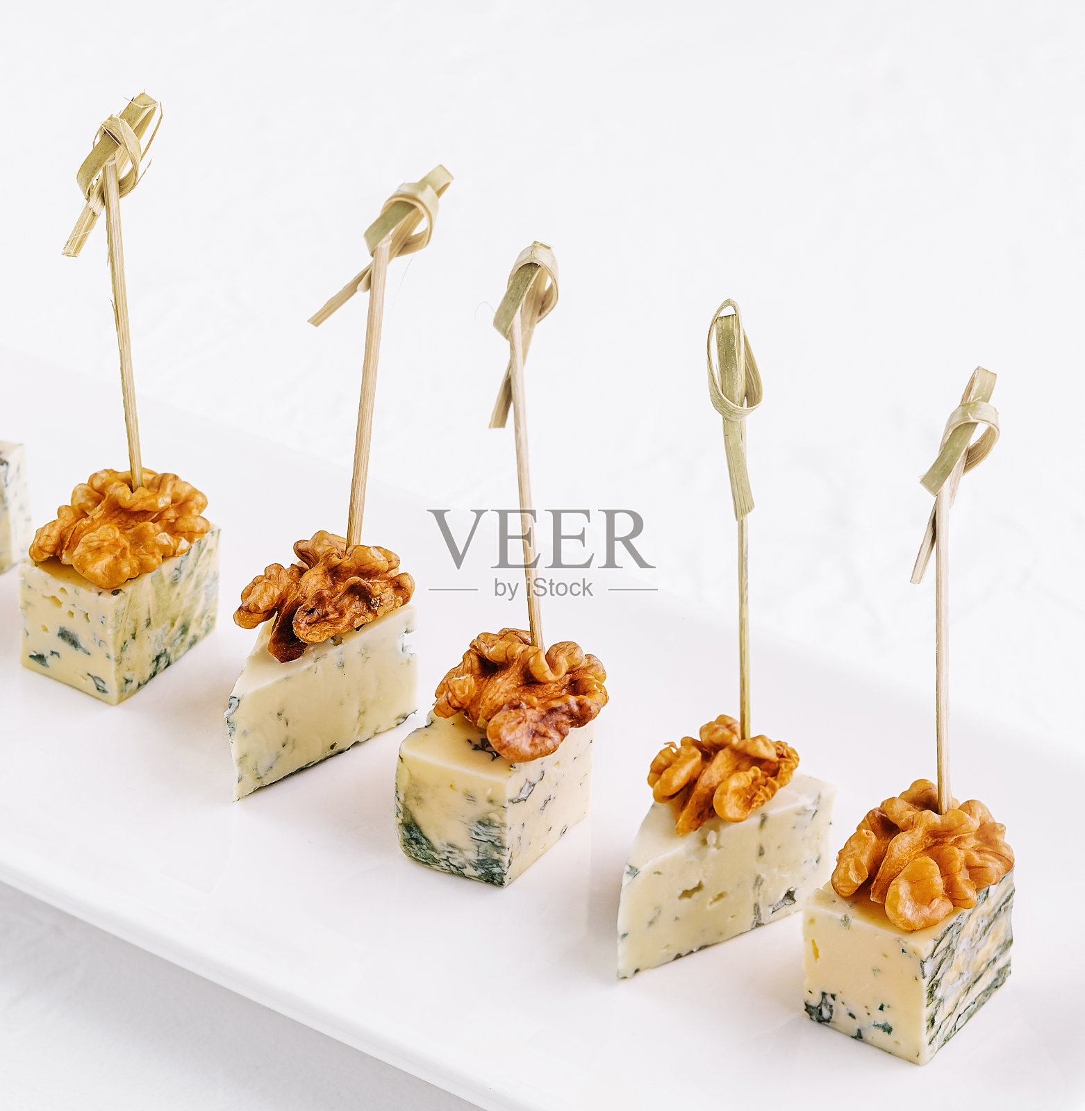 白色长盘子上的罗克福尔奶酪片照片摄影图片