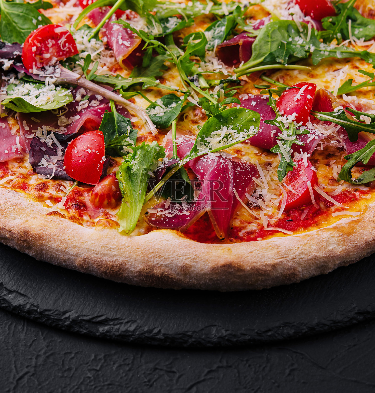 意大利披萨配火腿、芝麻菜和圣女果照片摄影图片