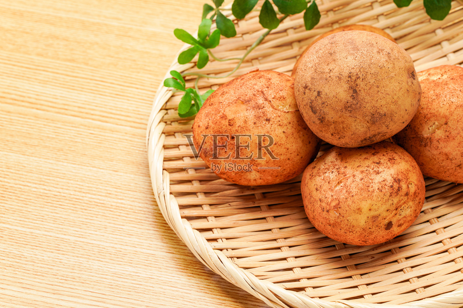 木桌上未削皮的生土豆照片摄影图片