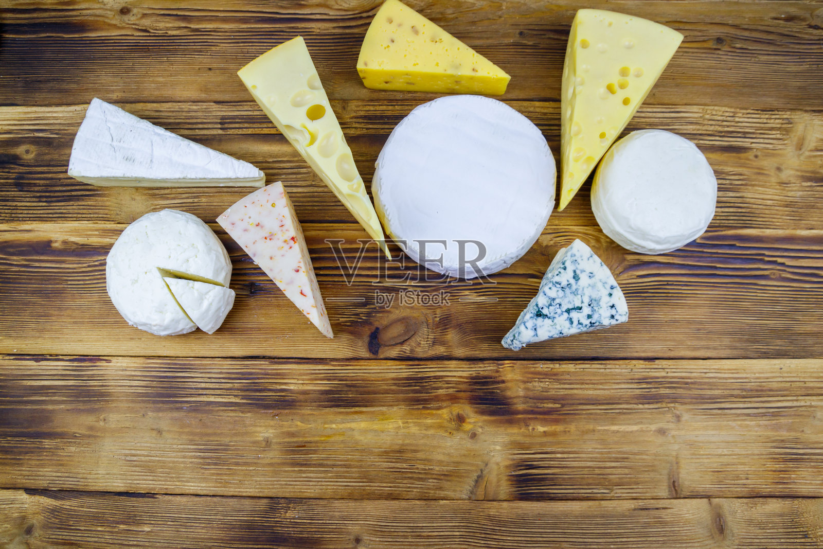 一套不同类型的奶酪在木桌上。俯视图照片摄影图片