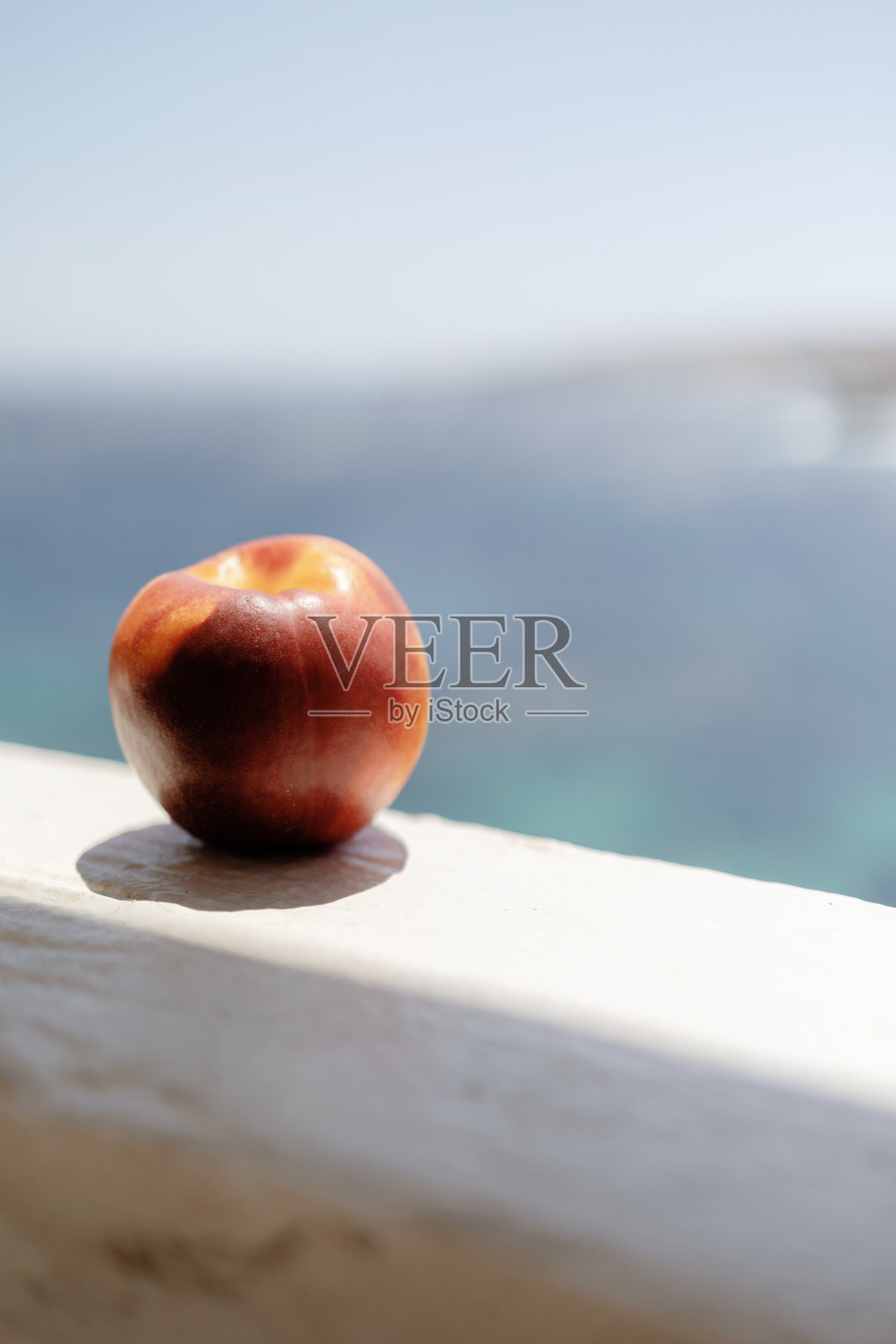 希腊基克拉迪群岛Serifos的Agios Sostis，基克拉迪群岛墙上的油桃。背景是Serifos的Agios Sostis海滩。照片摄影图片