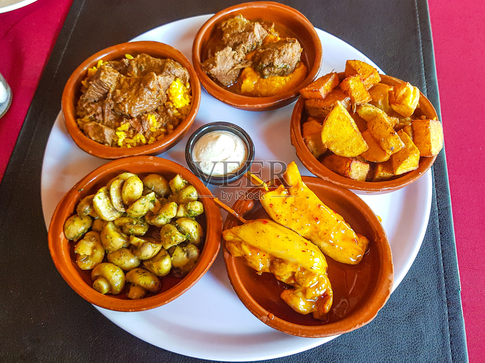 各种美味的小菜放在小泥盘里照片摄影图片