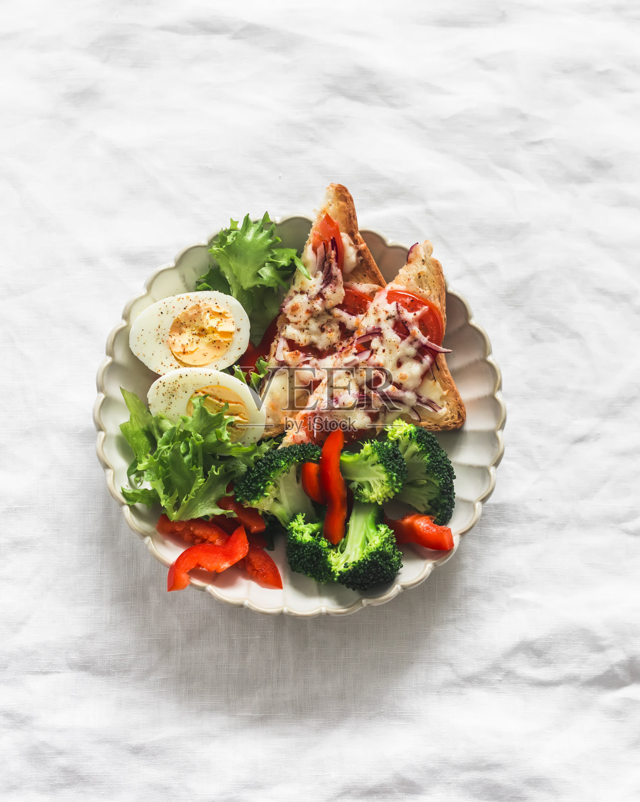 美味的减肥午餐，早餐-煮鸡蛋，新鲜蔬菜沙拉，西兰花和热三明治与番茄和奶酪在浅色背景，俯视图照片摄影图片