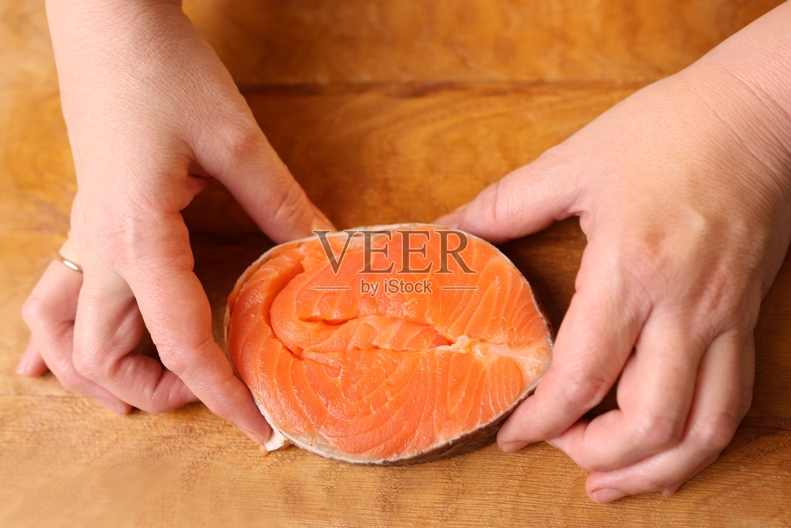 烤的时候，一块三文鱼被包成一个圈照片摄影图片