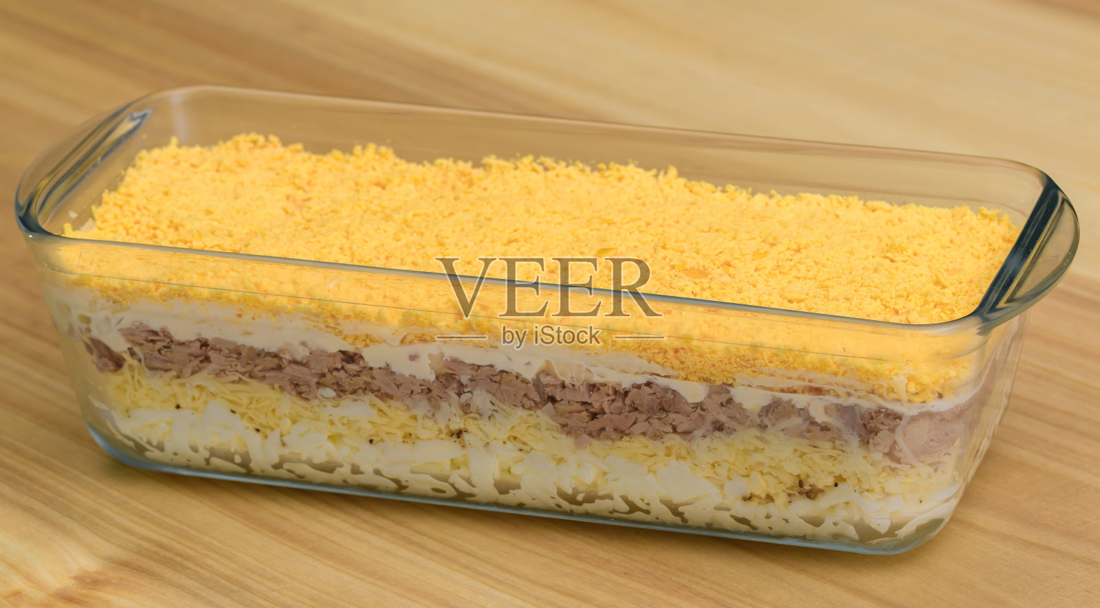 复活节用玻璃沙拉碗盛有鸡蛋、奶酪和金枪鱼的分层沙拉照片摄影图片