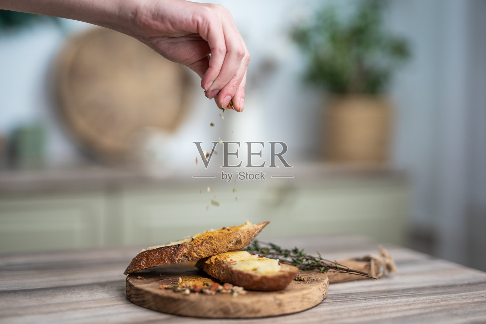 把调味料倒在一块木板上的三明治和黄油上照片摄影图片